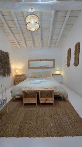 a bedroom with a large bed and a table at Casa do Castelo Terena in Alandroal