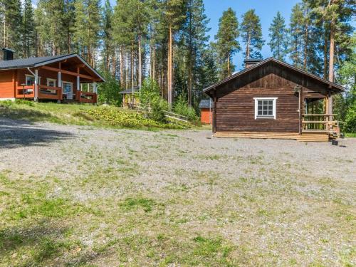 a cabin in the woods next to a field at Holiday Home Hankamaja by Interhome in Ihamaniemi