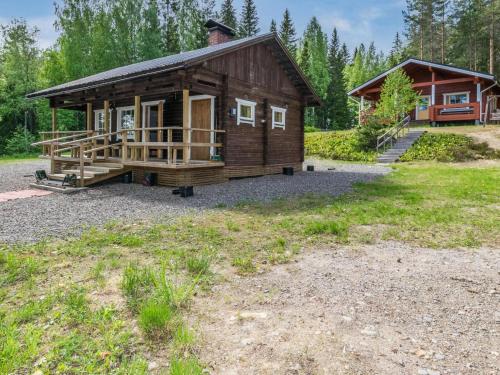 a log cabin with a porch and a house at Holiday Home Hankamaja by Interhome in Ihamaniemi