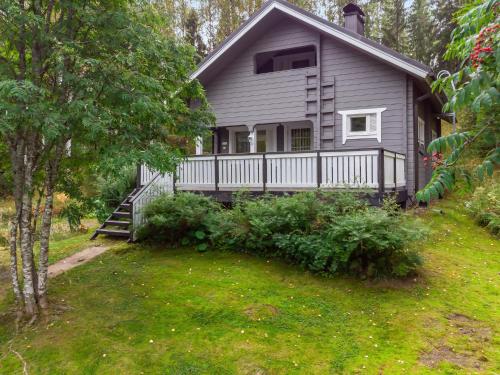 a gray house with a white fence and a yard at Holiday Home Kiikkukallio by Interhome in Hankamäki