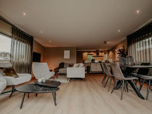a living room with chairs and a table and a kitchen at Holiday Home De Woude by Interhome in Uitgeest
