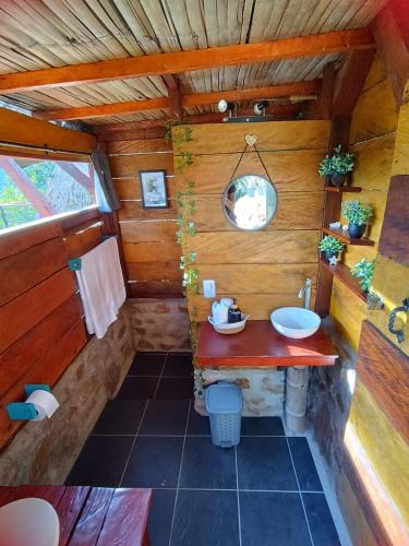 a bathroom with a sink in a wooden cabin at Cabanas ecologicas con vista espectacular y cascada privada - Finca Qawana Ecolodge en San Carlos in Cristalina