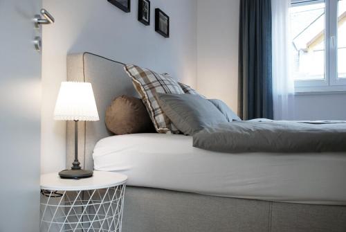 a bedroom with a couch with pillows and a lamp at LUX Ferienwohnung im Weinort Pommern an der Mosel in Pommern