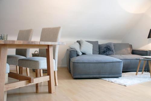 a living room with a couch and a table and chairs at LUX Ferienwohnung im Weinort Pommern an der Mosel in Pommern