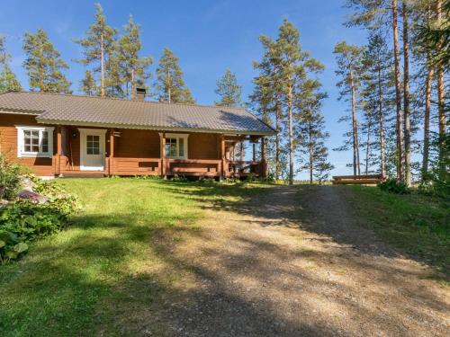a house on a hill with a dirt road at Holiday Home Lehtimaja by Interhome in Tiitanvaara