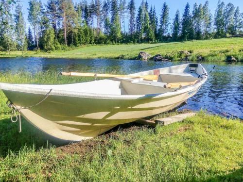 a boat sitting on the side of a river at Holiday Home Sillankorva by Interhome in Korpijärvi
