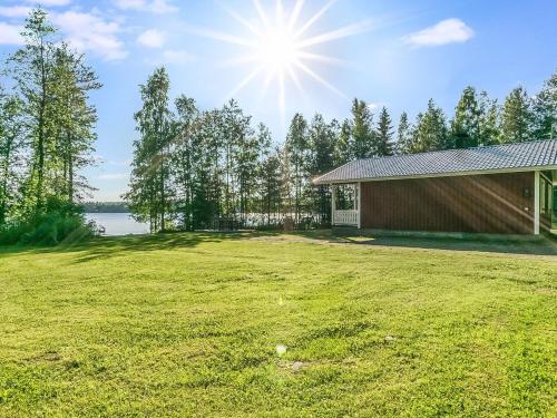 a house with a large yard next to a lake at Holiday Home Laavusranta by Interhome in Kantala