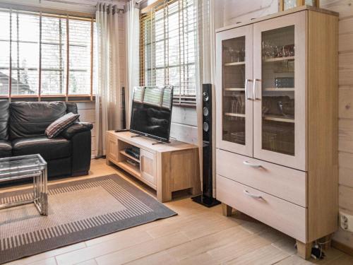 a living room with a black couch and a tv at Holiday Home Villa illi by Interhome in Tahkovuori