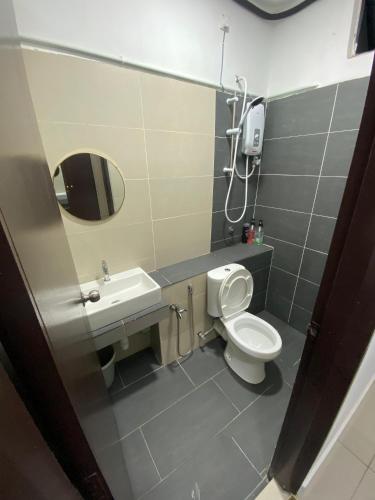 a bathroom with a toilet and a sink and a mirror at Mekla Hotel Studio Apartment in Gua Musang