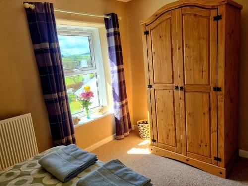 a bedroom with a large wooden cabinet and a window at Horse & Farrier Pub in Dacre