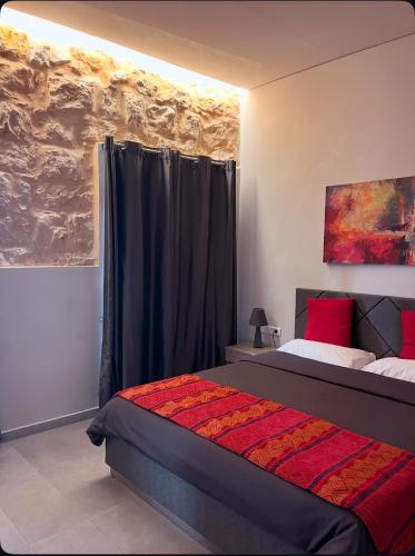 ein Schlafzimmer mit einem Bett mit schwarzen Vorhängen und roten Kissen in der Unterkunft Beit Lebbos Boutique Hotel in Beit ed-Din