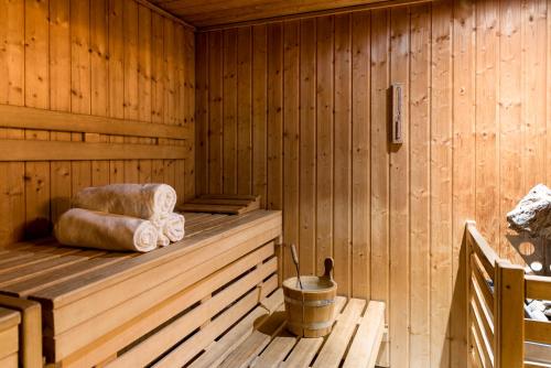 a wooden sauna with towels and a bucket in it at Novotel Genève Centre in Geneva