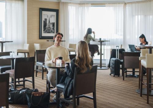 a man and woman sitting at a table in a restaurant at Delta Hotels by Marriott Montreal in Montreal