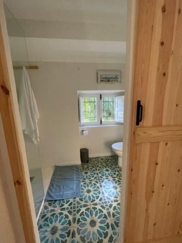 a bathroom with a toilet and a tile floor at Casita Molivent in Parcent