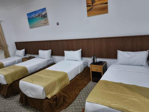 a group of three beds in a room at فندق الواحة الماسية نجمة 1 in Mecca
