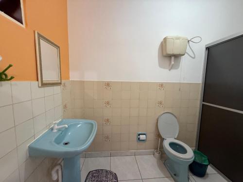 a bathroom with a blue sink and a toilet at Recanto Aconchego Itapoá in Itapoa