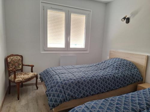 a bedroom with a bed and a chair and a window at Au gîte de Marcelle in Labergement-lès-Seurre