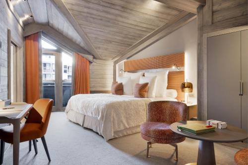 a bedroom with a bed and a table and chairs at Hotel Le K2 Chogori in Val-d'Isère