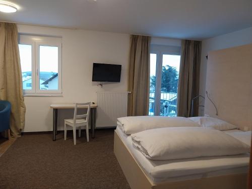 a hotel room with two beds and a desk and a television at Gästehaus Langhammer in Bubenreuth