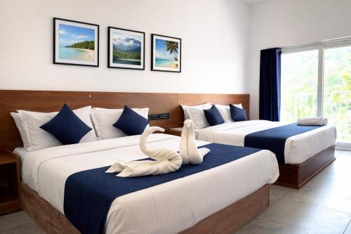 a hotel room with two beds with swans on them at Mount court munnar in Munnar