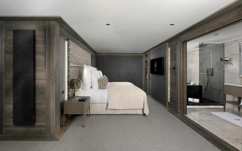 a bedroom with a bed and a walk in shower at Hotel Le K2 Chogori in Val-d'Isère