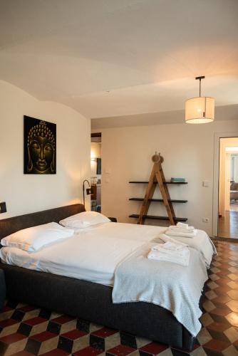 a bedroom with a large bed with a mask on the wall at Tenuta Dei Vicini - Luxury Apartments in San Marzano Oliveto
