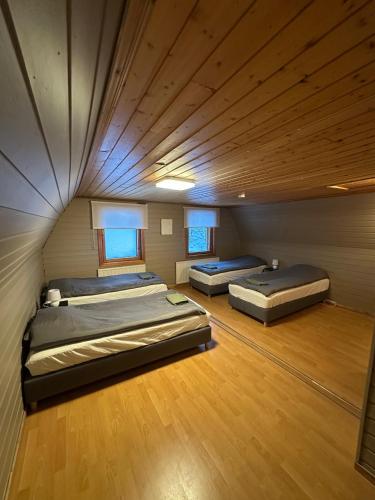 Zwei Betten in einem großen Zimmer mit Holzboden in der Unterkunft Hej hus! in Nikkala