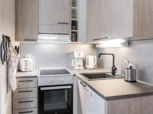 a small kitchen with a stove and a sink at Holiday Home Sini 2b by Interhome in Lahdenperä