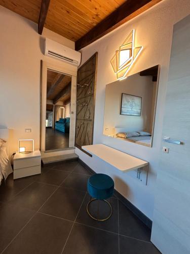 ein Schlafzimmer mit einem weißen Schreibtisch und einem blauen Hocker in der Unterkunft Agriturismo Risaltro in Trino