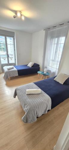 a hotel room with two beds and two windows at Le Charme du Sanctuaire 8 couchages 400m de la Grotte in Lourdes