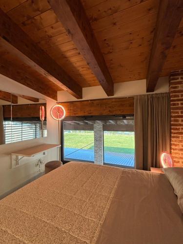 ein Schlafzimmer mit einem großen Bett und einem großen Fenster in der Unterkunft Agriturismo Risaltro in Trino