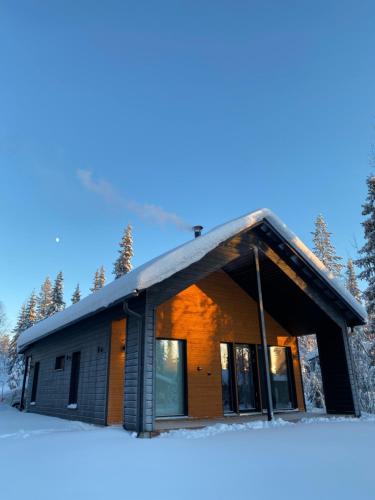 a house in the snow with the sun shining on it at Villa Luokka, Iso-Syöte in Syöte