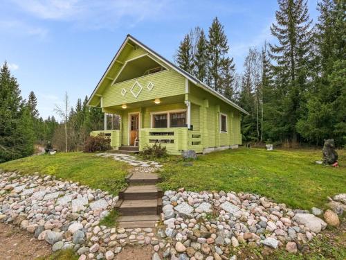 a green house with a pile of rocks at Holiday Home Metsämökki by Interhome in Barkarböle