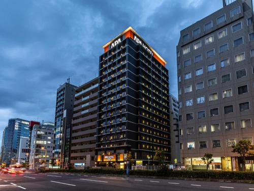 a tall black building with an orange top at APA Hotel Osaka Temmabashi Ekimae in Osaka