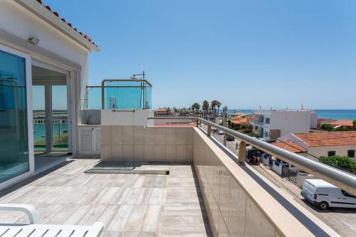 a balcony of a house with a view of the ocean at Blife Charlya private rooms at Faro beach in FAO