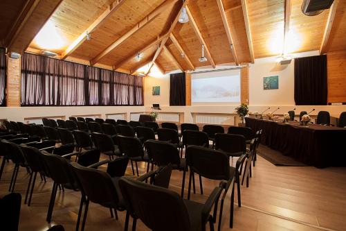 a room with rows of chairs and a projection screen at Hotel Junior in Kopaonik
