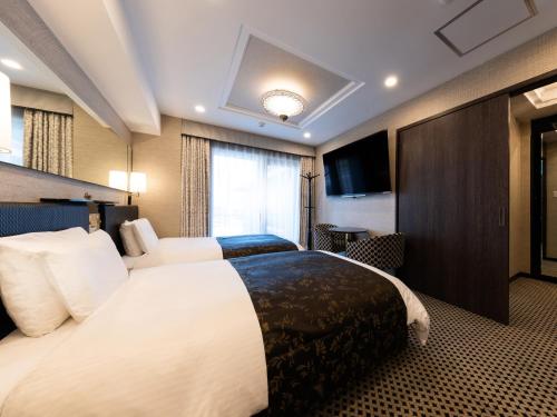 a hotel room with a large bed and a television at APA Hotel Osaka Temmabashi Ekimae in Osaka