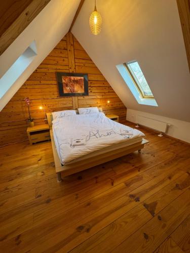 a bedroom with a bed in a attic at Frida Farm Vendégház in Kétvölgy