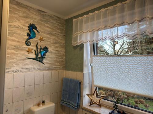 a bathroom with a seahorse painting on the wall at Ferienwohnung Schröder in Putbus