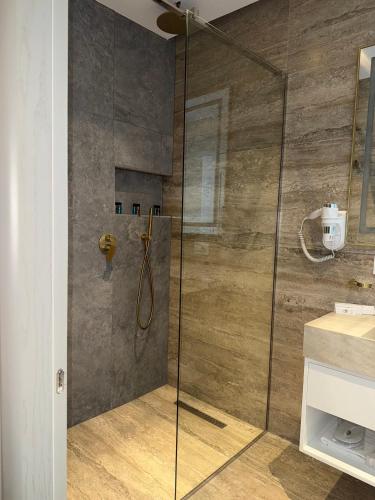 a shower with a glass door in a bathroom at Hani i Gjelit Hotel, Korce in Korçë