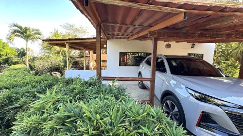 a white car parked under a wooden pergola at Montezuma Hills - Twin Houses in private compound - 4' to Downtown in Montezuma