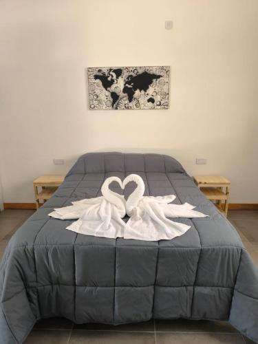 a bed with two white swans forming a heart at AlojaMenta in Nono