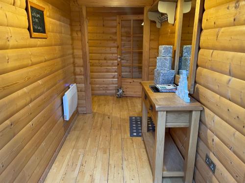 a cabin with a wooden floor and a table in a room at The Fairways, Kenwick Retreats in Louth