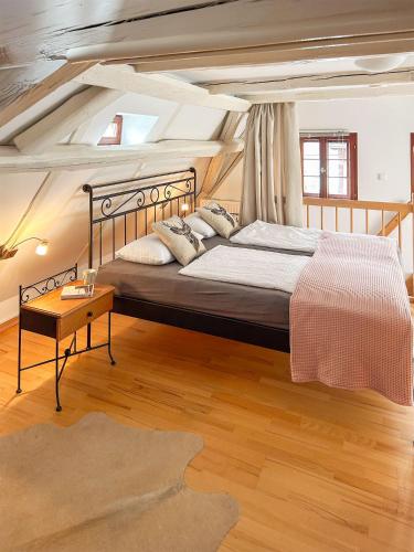 a bedroom with a large bed and a wooden floor at Ferienwohnungen Elbjuwel in Rathen