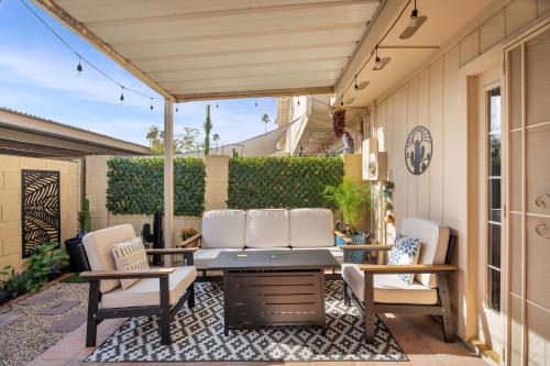 a patio with white chairs and a table at Old Town | Pool | BBQ | End Unit | Pet in Scottsdale