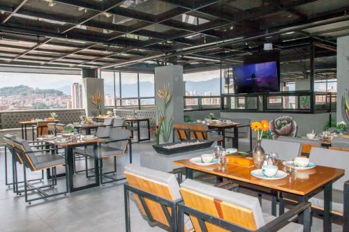 a restaurant with tables and chairs and a flat screen tv at Edificio Helena in Medellín