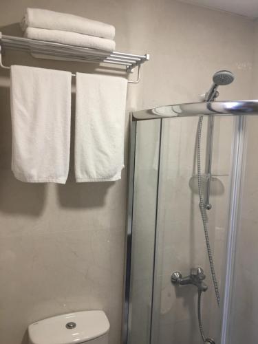 ein Badezimmer mit Dusche, Toilette und Handtüchern. in der Unterkunft Beit Lebbos Boutique Hotel in Beit ed-Din