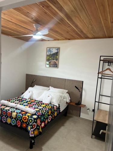 a bedroom with a bed with a wooden ceiling at ALHAMBRA location saisonnière in Sainte-Rose