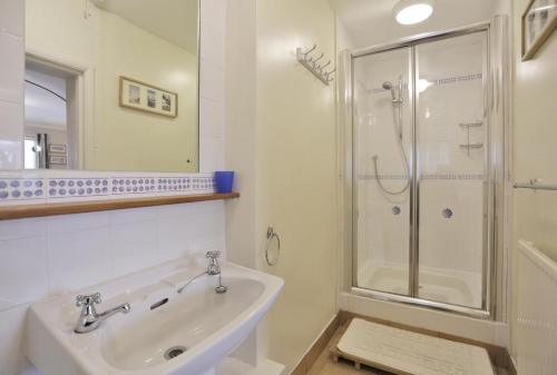 a white bathroom with a shower and a sink at 1 Bed in Frostenden oc-phc in Frostenden