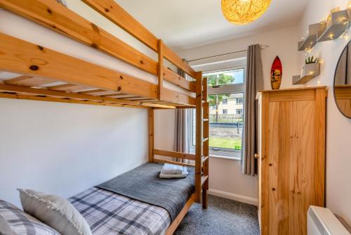 a bedroom with two bunk beds and a window at 3 Bed in Braunton oc-b29581 in Braunton
